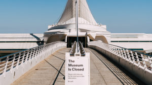 The entrance walkway to a museum with a sign displayed announcing the museum's closure.