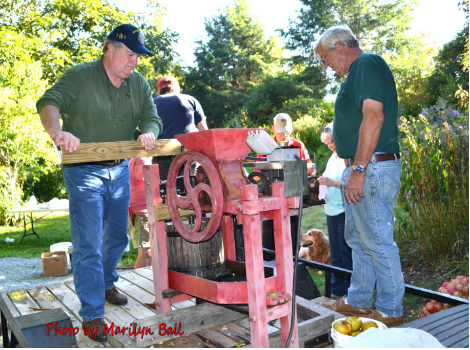 Two men using an apple mill